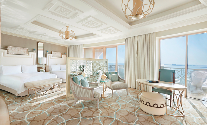 Ylellinen hotellihuone parvekkeella, jolta avautuu näkymä merelle, sekä kahdella Queen-sängyllä